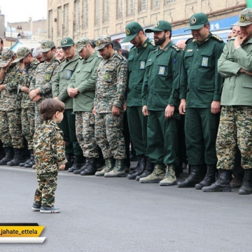 تصویری از فرزند شهید مدافع حرم اکبر زوار در برابر همرزمان پدر